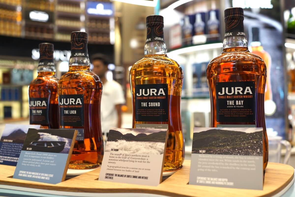 Butelki whisky wyeksponowane na stole wraz z opisem każdej z nich