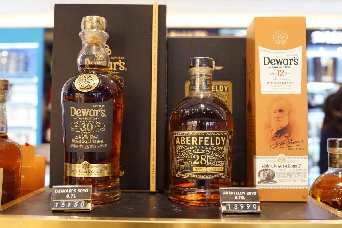 Dwie eleganckie butelki z alkoholem na tle opakowań