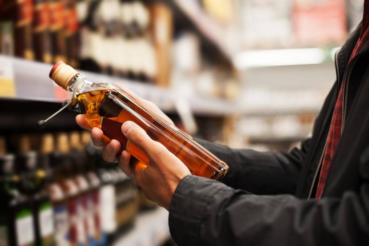 mężczyzna trzymający butelkę whisky