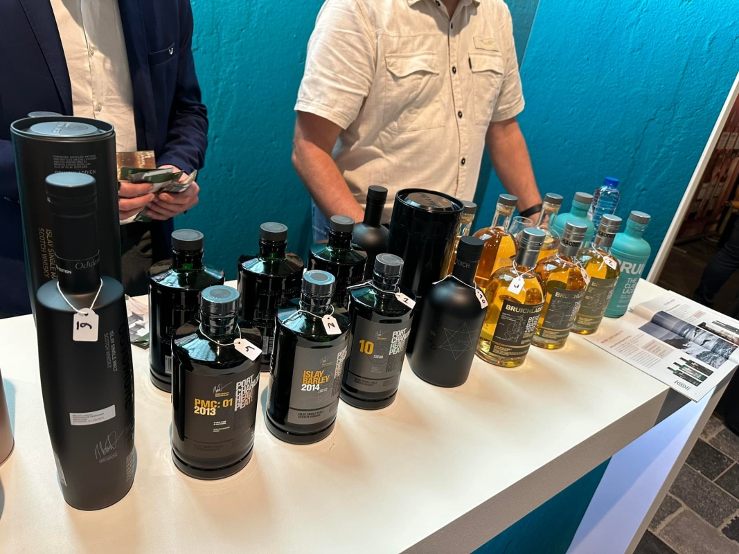 dwie osoby przy butelkach z whisky